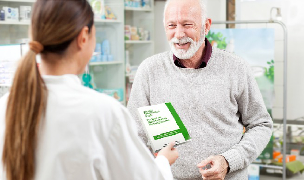 An image shows, doctor giving a Pharmacy book to an older man.